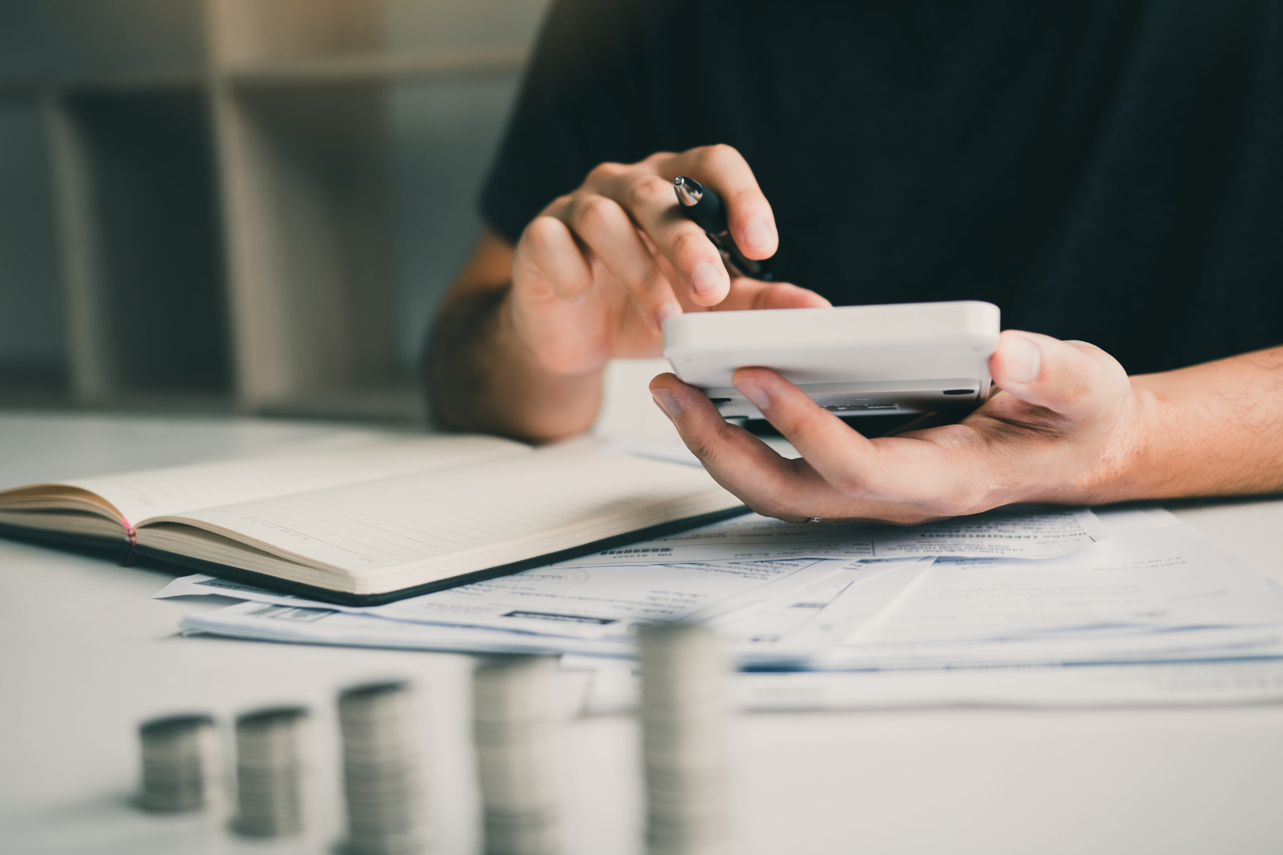 Man use calculators and documents that calculate expenses in the home office.