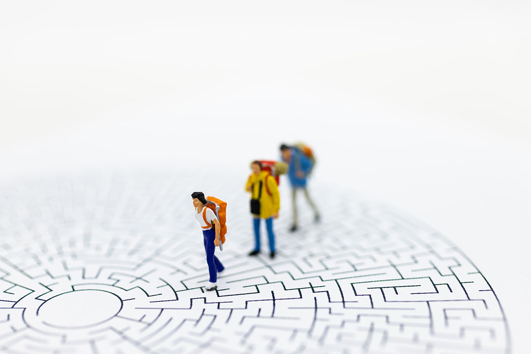 Miniature people: Tourists walk on the maze map. Image use for