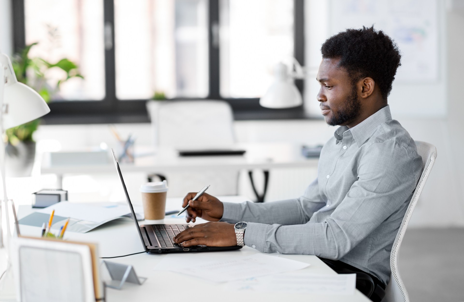 man with coffee working at a laptop computer